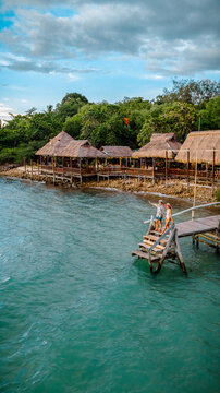 Couple tourist in happiness and relax moment on wooden pier, enjoy the summer trip in tropical island