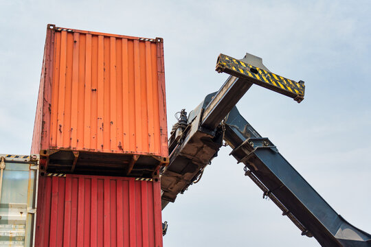 Reach stacker lifting shipping container in freight yard terminal logistics distribution depot