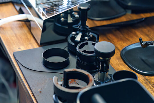 Professional espresso coffee tampering tools and accessories on wooden counter in cafe bar