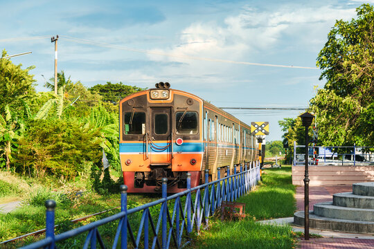 Old diesel train running at rural railway station in sunny at Thailand countryside