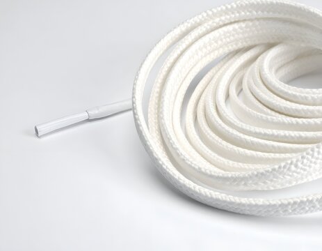 Coiled white shoelace on white background.