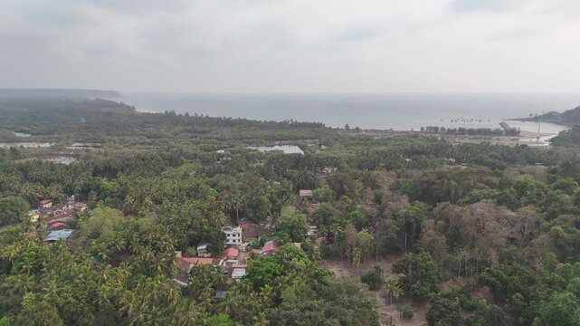Breathtaking landscape where lush green woods meet the ocean waves along the Ratnagiri belt of the Konkan coast. Serene and unexplored tropical beach environment in India.
