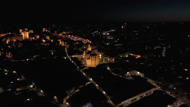 Aerial approach to the illuminated Church of San Francisco Javier in C&aacute;ceres at night