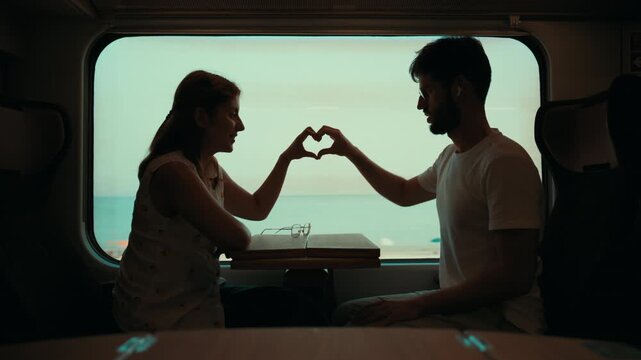 Silhouette of a couple make heart shape during valentines day on the train