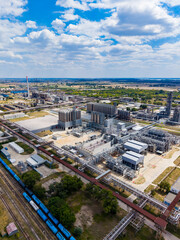 Fototapeta premium Industrial site with pipelines and processing units in a rural area during daylight