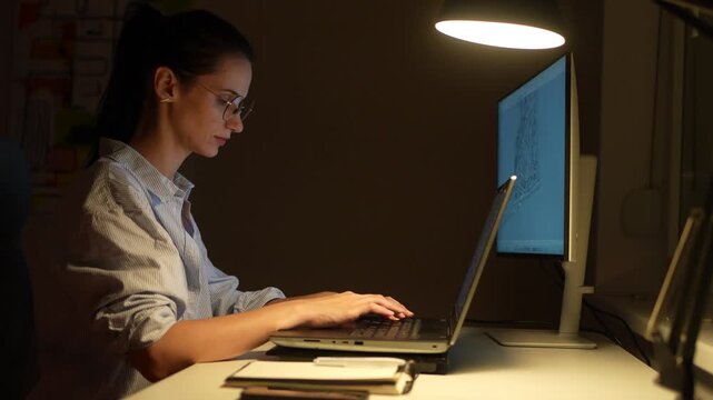 Female freelancer working late in home office using laptop