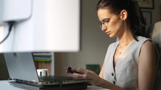 Businesswoman using a smartphone while working in a home office