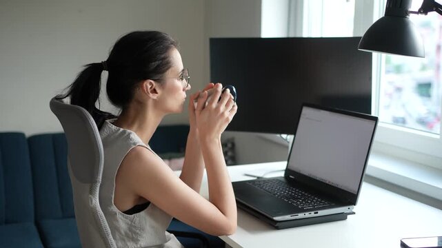 Businesswoman drinking coffee while working