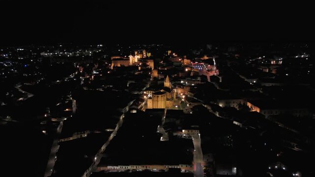 Illuminated Church of San Francisco Javier above the medieval cityscape of C&aacute;ceres