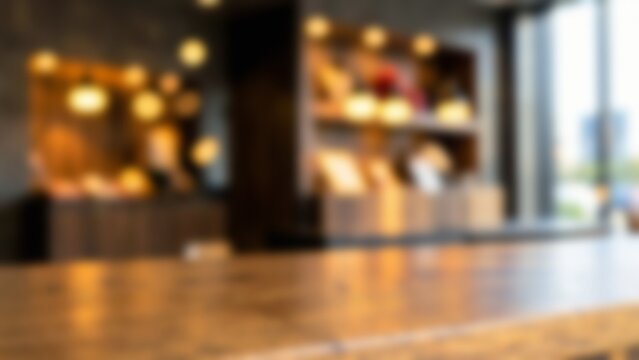 Blurred empty wooden table top in warm modern cafe interior background for commercial product placement, display mockups and website banner design