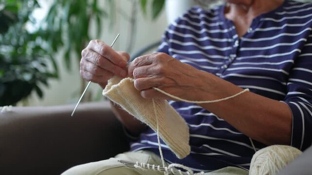 Close up of senior woman knitting at home