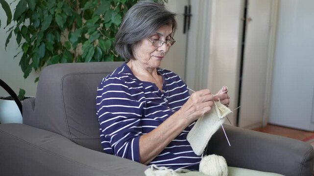 Woman knitting while relaxing at home