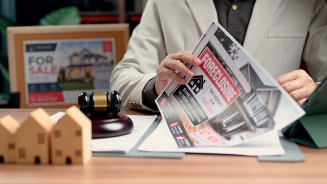 Lawyer evaluating property contract document manages business agreements, resolving conflict as senior lawyer inspects property files alongside junior lawyer.
