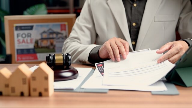 Experienced lawyer evaluates property contract regarding business agreements, avoiding conflict supervising lawyer inspects property records as chief lawyer signs.