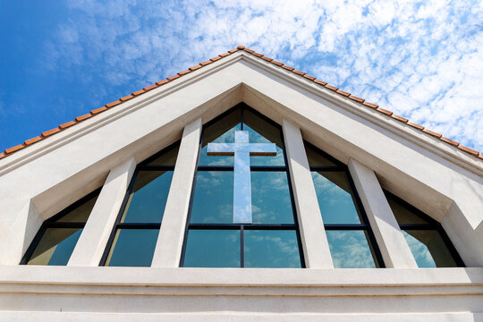Modern Church Facade with Cross Against Blue Sky