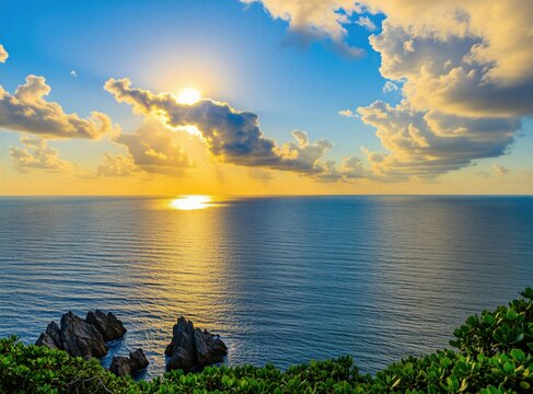Ocean waves crash on rocks near lush green cliffside during a vibrant sunset. Golden sun reflects on calm sea surface, blue sky filled with soft clouds.