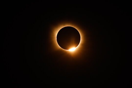 Spain - 12 August 2026: View of a total solar eclipse with the moon obscuring the sun, creating a bright corona and a diamond ring effect against the dark night sky in Spain.