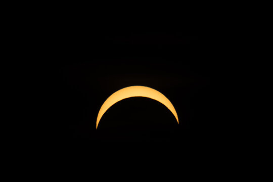 Berlin, Germany - 12 August 2026: View of a partial solar eclipse with the moon partially obscuring the sun in the dark sky.