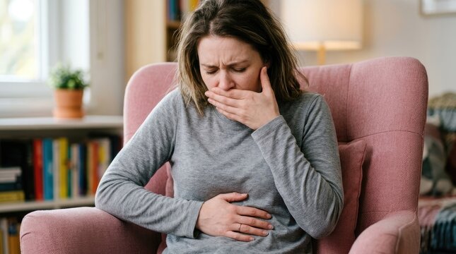 Woman suffering from nausea and stomach pain sitting at home