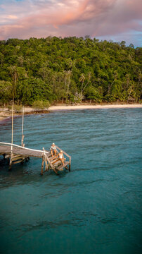 Couple tourist in happiness and relax moment on wooden pier, enjoy the summer trip in tropical island