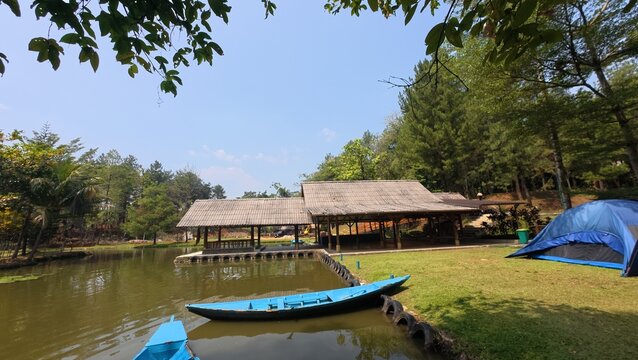 Scenic view of a traditional rowboat tied to a wooden dock on a beautiful lake.