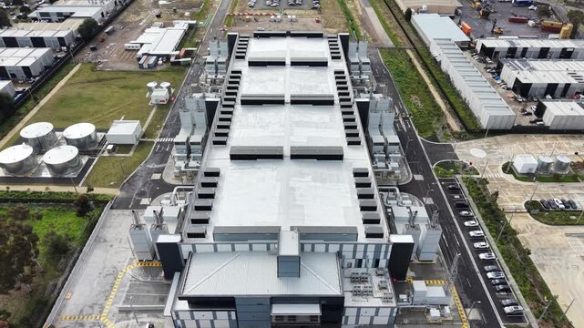 Aerial view flying over large industrial data center building
