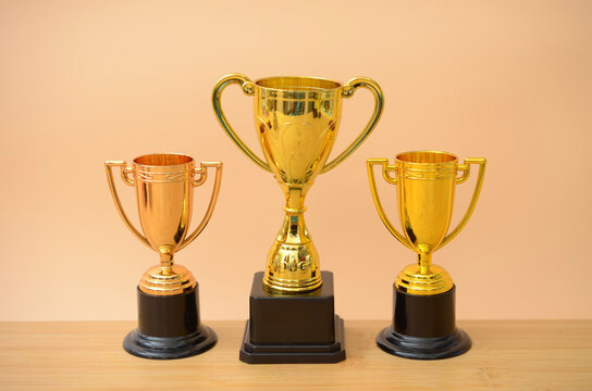 Three Gold Trophies Representing Ranking and Top Performance