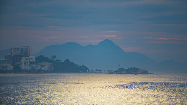 Golden twilight on Rio de Janeiro coast with Arpoador rock and mountains in Brazil
