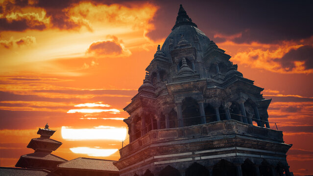 Ancient stone temple at spectacular fiery sunset on Durbar square in Kathmandu Nepal