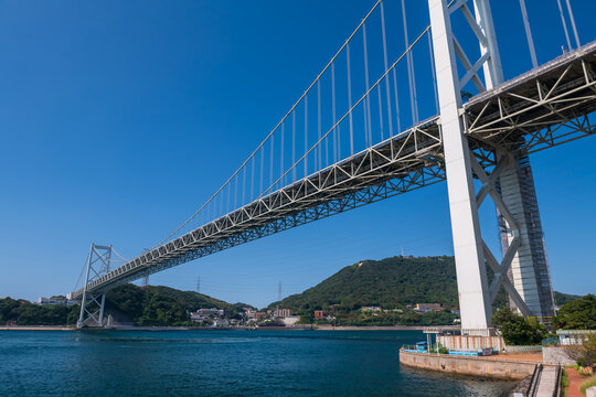 Iconic Kanmon Bridge by strait against blue sky, Kitakyushu, Fukuoka