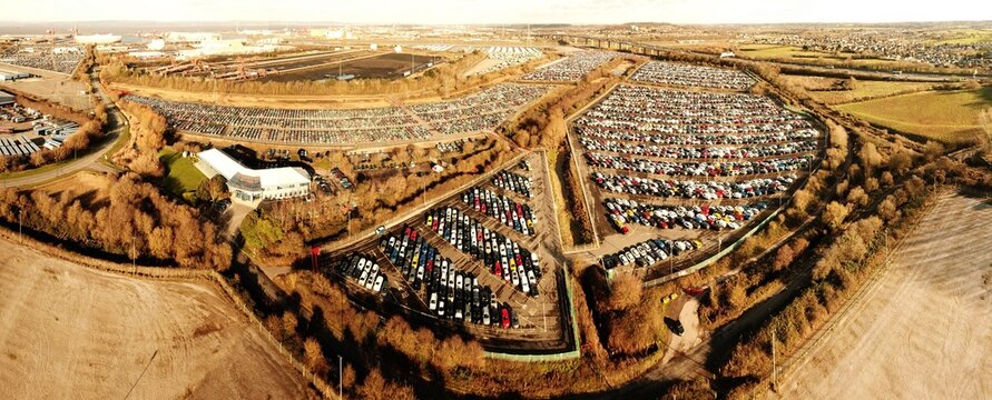 Aerial view of a large car storage facility filled with rows of imported cars, Severn Estuary, United Kingdom.