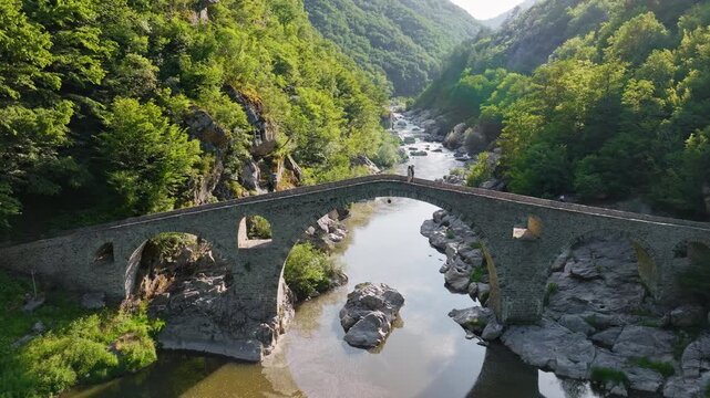 Dyavolski Most Devils Bridge medieval stone arch bridge over Arda river gorge canyon aerial drone view lush green forest landmark historic travel site Bulgaria
