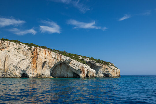 Breathtaking sky and white limestone cliffs blue cave crystal sea rocky Greek coast summer. Beautiful coastal nature seascape landscape. Scenic Mediterranean travel adventure outdoors background