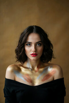 Portrait of a woman with metallic paint on her upper torso and shoulders