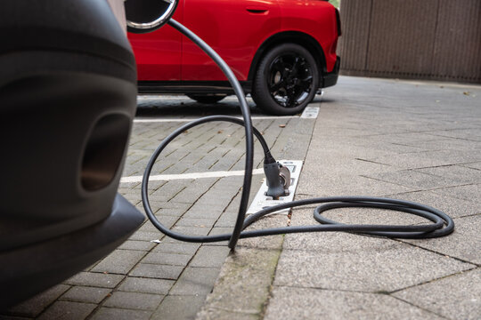 Ein E-Auto wird an einem Ladebordstein auf der K&Ouml; mit einem Kabel aufgeladen, D&uuml;sseldorf, Deutschland