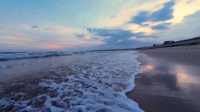 Serene empty golden sand beach during early morning golden hour, static view.