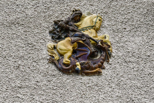 Colorful ceramic relief sculpture of Saint George and the dragon on a rough plastered house wall in Portofino, Liguria, Italy