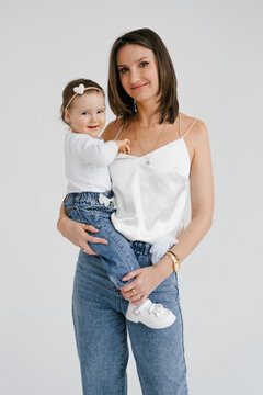 Happy Mother Holding Smiling Toddler Girl Standing