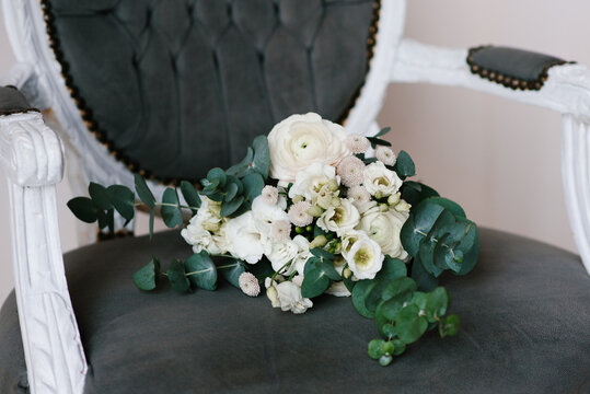 Bridal Bouquet with White Roses and Eucalyptus on Velvet Chair