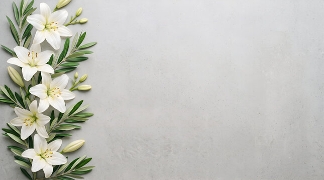 White lilies and olive leaves border on grey background with copy space for wedding design.