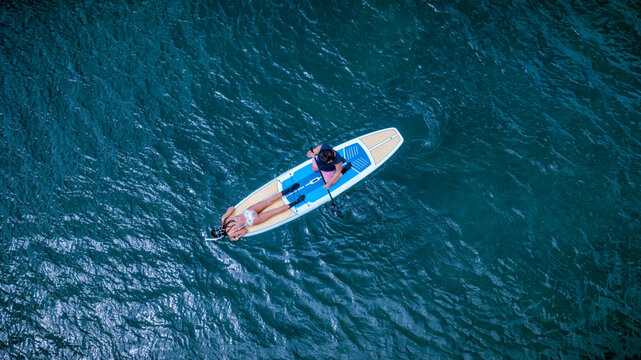 Top aerial view of Group of tourist are enjoy on water sport paddle sup-board  along at the sea under crystal clear of water in the island of summer trip