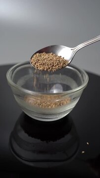 Ajwain Seeds Gracefully Fall into a Glass Bowl: A Culinary Delight for Cooking and Herbal Remedy