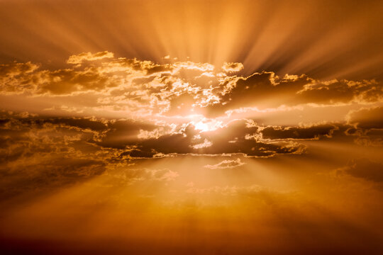 A dramatic sky with the sunrise breaking through the clouds and its distinct rays