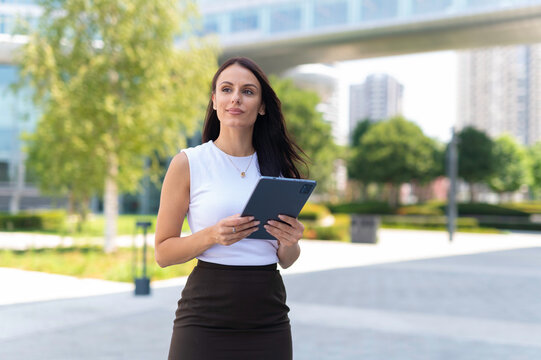 Businesswoman holding tablet looking into the future