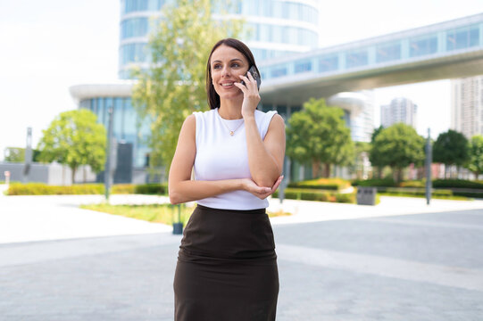 Businesswoman talking on smartphone outside office building