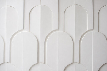 Obraz premium A white, modern architectural wall paneling design featuring repeating arched and curved geometric patterns.