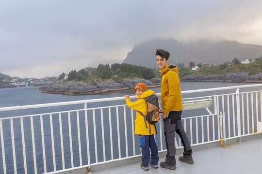 People, enjoying ferry ride between Bodo and Lofoten Moskenesoya summertime, child and adults on a ferry on sunset