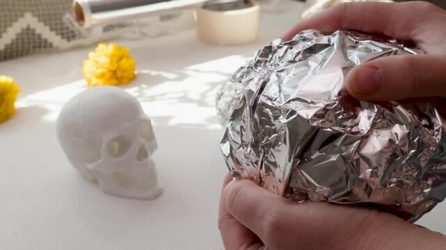 Papermache skull base wrapped in foil for DIY Day of the Dead calavera prep