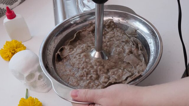 Hand-stirred papier-mache paste thickening for DIY Dia de los Muertos skull craft