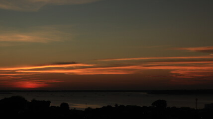 Fototapeta premium Low orange sunset in dramatic clouds over ocean 
